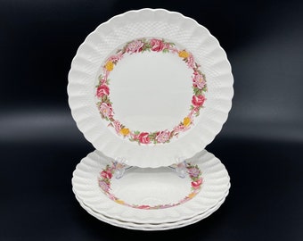 Op de afbeelding: Drie witte keramische dinerborden met een bloemenmotief. De borden hebben een gegolfde rand en een reliëfpatroon.