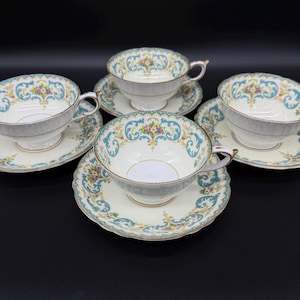 May include: Set of four vintage teacups and saucers with a floral and scroll design in shades of blue, green, and gold.