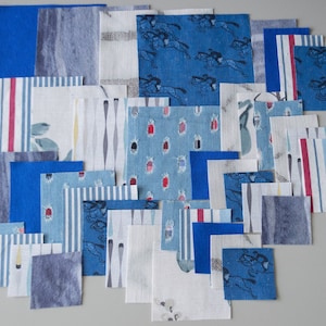 May include: A collection of fabric squares in various shades of blue, white, and red. The squares feature different patterns, including stripes, polka dots, and geometric designs. Some squares have a subtle texture, while others are smooth.