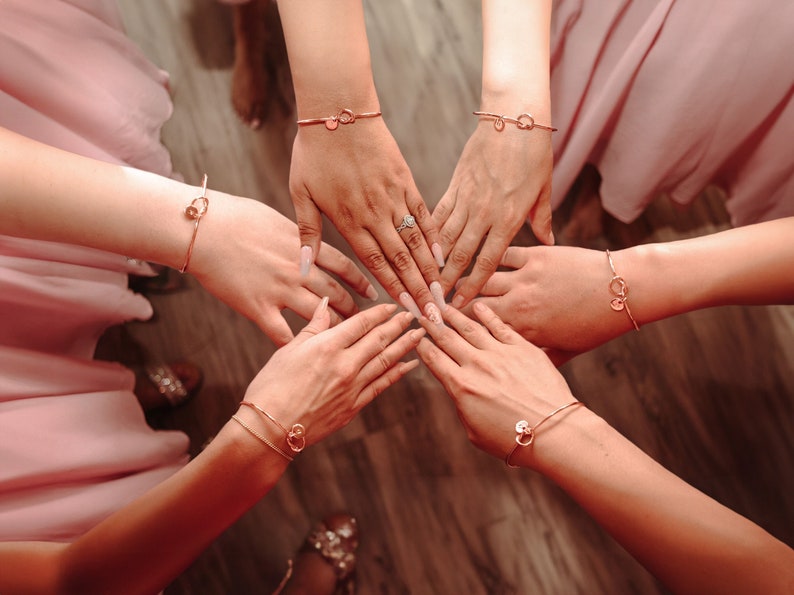 A handcrafted knot bracelet with an elegant design, featuring a personalized initial charm. The knot and unique charm add a personalized touch, making it a perfect accessory for any outfit. Ideal for adding a subtle yet distinctive statement.