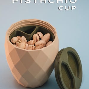 May include: A pistachio cup with a green lid. The cup is made of a beige, textured material and has a geometric design. The lid has three compartments and is also made of a green, textured material.