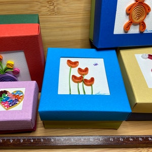 Caja de cartón de 280g, plegada y decorada con la técnica de quilling. Bonito packaging para un regalo bonito, original y colorido