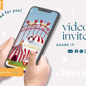 May include: A smartphone displaying a video invite with a circus theme. The video features a Ferris wheel and a circus tent. Text on the screen reads "Adriel is turning 1!" and "video invite". The phone is held in two hands.