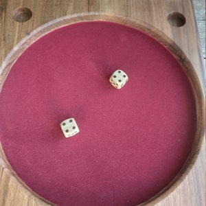 May include: A wooden game board with a red felt playing surface. Two dice have been rolled onto the felt surface. The numbers 6, 7, 8, and 9 are written on the board.
