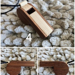K&ouml;nnte beinhalten: Ein h&ouml;lzerner Pfeifenanh&auml;nger mit zweifarbigem Design aus dunkelbrauner und hellbeiger Holzmaserung, befestigt an einer d&uuml;nnen schwarzen Kordel. Die Pfeife hat einen rechteckigen K&ouml;rper und ein abgerundetes Seitenprofil, mit der Zahl 4 im Bild.