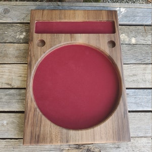 May include: A wooden tray with a circular, red felt-lined compartment and a smaller rectangular compartment. The tray has two small holes on the side.