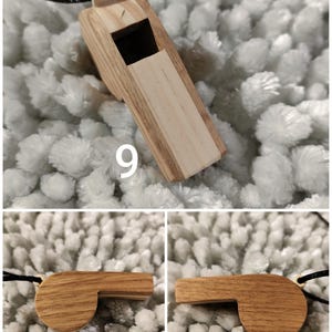 K&ouml;nnte beinhalten: Eine Holzpfeife mit heller Maserung und dunkelbraunem Seitenprofil, befestigt an einer schwarzen Kordel. Die Pfeife verf&uuml;gt &uuml;ber ein rechteckiges Mundst&uuml;ck und eine quadratische Schallkammer&ouml;ffnung. Die Zahl 9 ist auf der Draufsicht aufgedruckt.