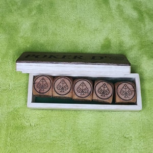 May include: A wooden box with the words "Poker D'" on the lid. The box contains six wooden dice with a spade symbol on each face.