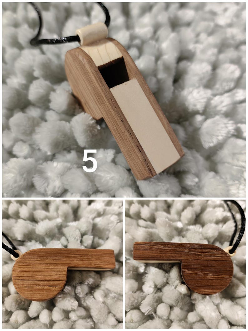 K&ouml;nnte beinhalten: Ein h&ouml;lzerner Pfeifenanh&auml;nger mit zweifarbigem Design aus hellem und dunkelbraunem Holzmaserung, einer schwarzen Kordel und der auf der Seite aufgedruckten Zahl 5. Die Pfeife hat ein rechteckiges Mundst&uuml;ck und einen abgerundeten K&ouml;rper.
