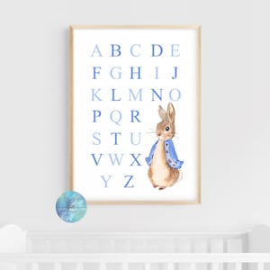 May include: A blue and white alphabet chart with a watercolor illustration of a brown rabbit wearing a blue jacket. The letters are in a gradient of blue.