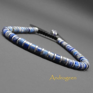 May include: A blue and silver beaded bracelet with a black cord closure. The beads are made of lapis lazuli and silver.