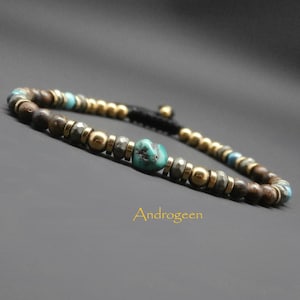Könnte beinhalten: Ein Armband mit braunen, goldenen und türkisfarbenen Perlen. Das Armband hat einen schwarzen Kordelverschluss.
