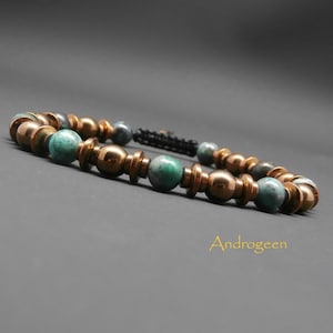 Peut inclure: Un bracelet avec des perles vertes et dorées. Le bracelet est composé d'un mélange de perles rondes et de perles d'espacement. Le bracelet est attaché avec un cordon noir.