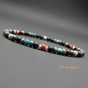 Peut inclure: Un bracelet en perles avec des perles noires, turquoise, dorées et rouges. Le bracelet est fait de pierres naturelles et a un design simple.