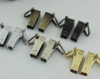 May include: Four pairs of metal clasps in different finishes: silver, brass, antique brass, and black. Each clasp has a loop on one end and a hook on the other.