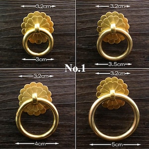 May include: Four gold-colored metal ring pulls with flower-shaped backplates. The top left pull has a 3 cm ring and 3.2 cm backplate. The top right has a 3.5 cm ring and 3.2 cm backplate. The bottom left has a 4 cm ring and 3.2 cm backplate. The bottom right has a 5 cm ring and 3.2 cm backplate.