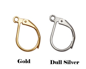 Könnte beinhalten: Zwei Ohrhaken, einer in Gold und einer in Silber. Die Haken sind aus Metall und haben ein schlichtes, klassisches Design.