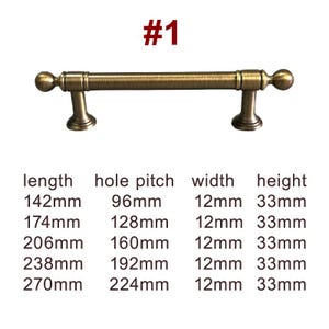 Könnte beinhalten: Schrankgriff im antiken Messing-Finish. Der Griff hat eine zylindrische Stange mit abgerundeten Enden und dekorativen Halterungen. Das Bild enthält Maße: Länge 142 mm, Lochabstand 96 mm, Breite 12 mm, Höhe 33 mm.