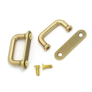 May include: A collection of brass hardware components, including two pull handles, a small rectangular plate, and two screws. The handles have a curved design, and the plate features a textured surface. The hardware is designed for furniture or cabinetry.