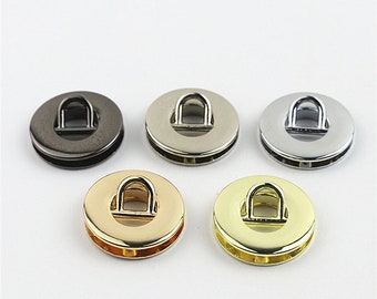 May include: Five metal rings with a D-shaped loop in the center. The rings are in different finishes: black, silver, nickel, gold, and brass.