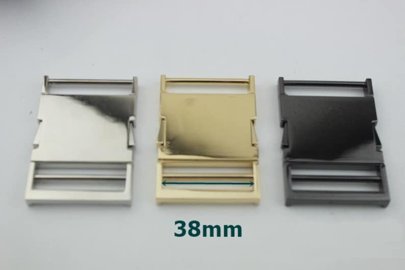 May include: Three metal belt buckle sliders in silver, gold, and black. Each slider measures 38mm in length.