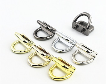 May include: Three sets of metal D-ring hardware in gold, silver, and black finishes. Each set has two D-rings and a connecting bar.
