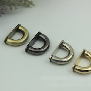 May include: Four metal D-rings in different finishes: antique brass, black nickel, silver, and gold. These rings are great for adding a touch of style to your bags, purses, or other crafts.