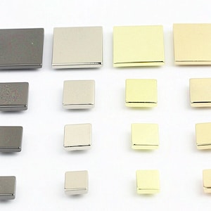 May include: Assortment of metal square buttons in various sizes and finishes, including gold, silver, and black.