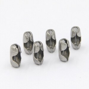 May include: Six silver metal chain end stoppers. The stoppers are cylindrical and have a small opening on each side.