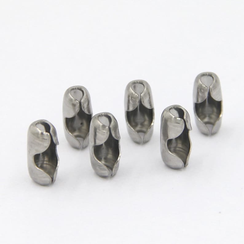 May include: Six silver metal chain end stoppers. The stoppers are cylindrical and have a small opening on each side.
