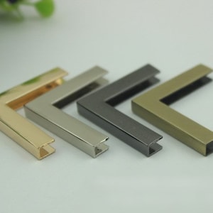 May include: Four metal corner protectors in different finishes: gold, silver, gunmetal, and brass. These corner protectors are ideal for protecting furniture, bags, and other items from damage.