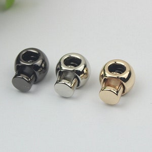 May include: Three metal toggle clasps in black, silver, and gold.