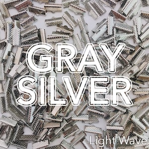 May include: A collection of small, gray and silver metal crimp end findings scattered across a surface. The text "GRAY SILVER" is superimposed over the findings. The words "Light Wave" are also visible.