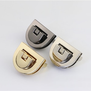 May include: Three half-circle metal clasps in gold, silver, and gunmetal finishes. Each clasp has a hinged latch.