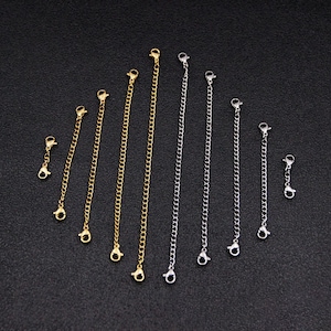 May include: A set of eight gold and silver extender chains for necklaces or bracelets. The chains are different lengths and have lobster claw clasps.