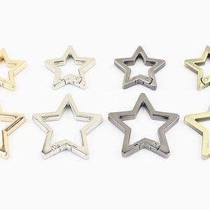 Puede incluir: Ocho llaveros de metal con forma de estrella en acabados dorado, plateado y bronce. Los llaveros tienen un cierre de resorte.