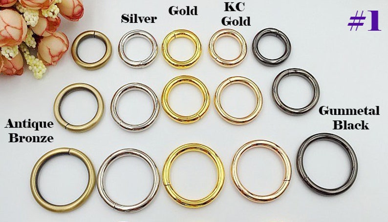 May include: Assortment of metal rings in various finishes, including antique bronze, silver, gold, KC gold, and gunmetal black. The rings are arranged in rows by color and are all the same size.