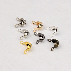 May include: Assortment of six metal bead caps in different finishes: silver, gold, black, and bronze. Each cap has two loops for attaching to a bead.