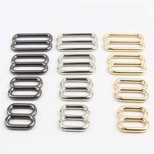May include: Assortment of metal slider buckles in three finishes: silver, gold, and black. The buckles are in various sizes and are ideal for crafting projects.