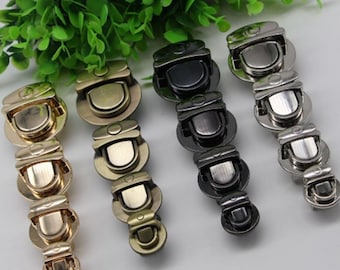 May include: Set of three handbag clasps in gold, silver, and black metal. Each clasp has a series of interlocking rings.