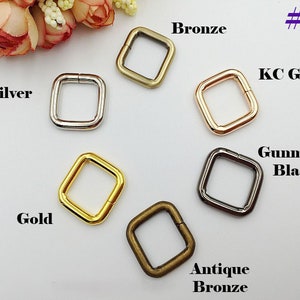 May include: Six square-shaped metal rings in different finishes: silver, gold, bronze, antique bronze, gunmetal black, and KC gold. #3