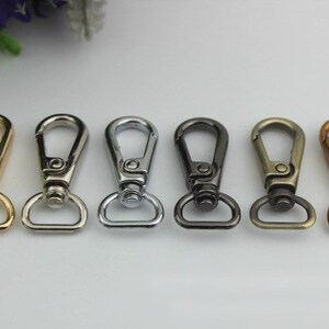 Könnte beinhalten: Sechs Metall-Drehverschlüsse in verschiedenen Ausführungen: Gold, Silber, Nickel, Antikmessing und Bronze. Diese Verschlüsse eignen sich hervorragend zum Anbringen an Taschen, Geldbörsen oder anderem Zubehör.