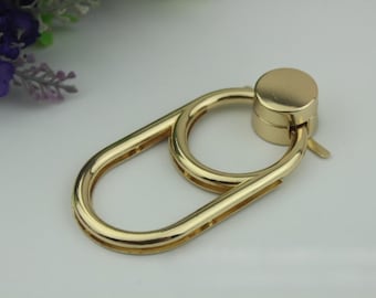 May include: Gold-toned metal swivel hook with a round top. The hook has a double loop design.