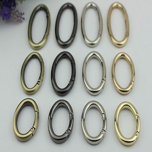 May include: Twelve oval-shaped metal key rings in four different finishes: antique brass, black, silver, and gold. The key rings have a spring-loaded clasp.