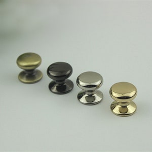 May include: Four cabinet knobs in different finishes: antique brass, black, nickel, and gold.