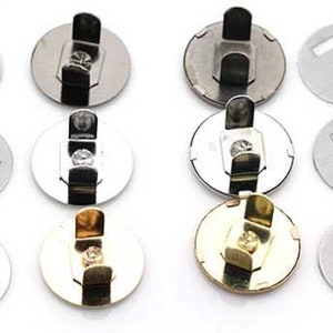 May include: A set of nine magnetic snaps in three finishes: silver, black, and gold. Each snap has a round base with a small hole in the center and a hook-like attachment on the top. The snaps are designed for use in sewing and crafting projects.