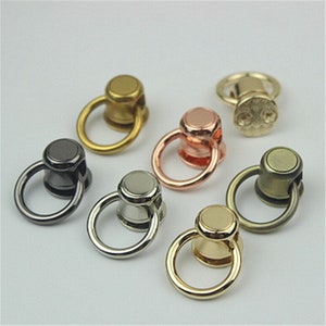 May include: Assortment of metal swivel snap hooks with a ring. The hooks are in various finishes including gold, silver, black, and bronze.