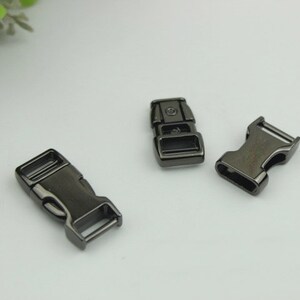 May include: Three black metal side release buckles. The buckles are about 1 inch long and have a matte finish.