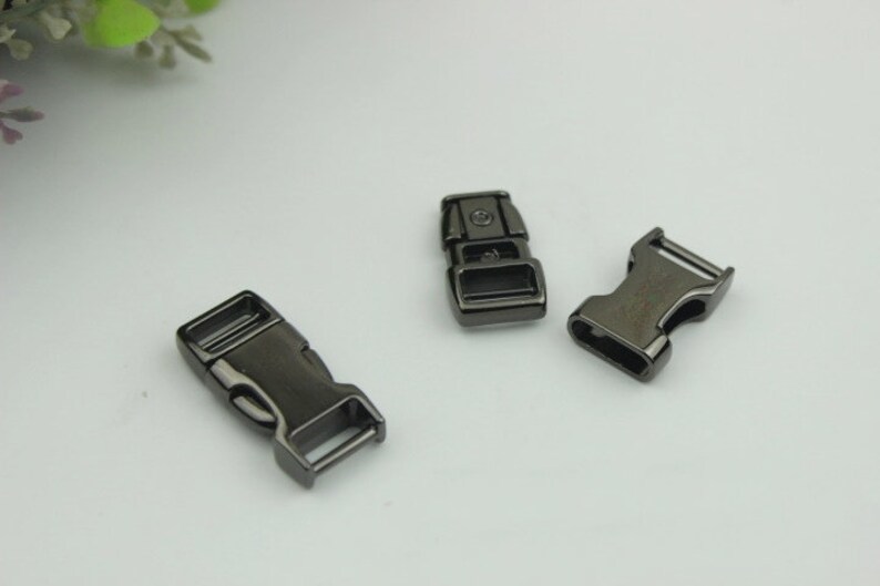 May include: Three black metal side release buckles. The buckles are about 1 inch long and have a matte finish.