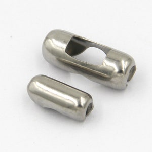 May include: Two silver metal end caps for a chain or cord. The larger end cap has a hole in the center. The smaller end cap is solid.